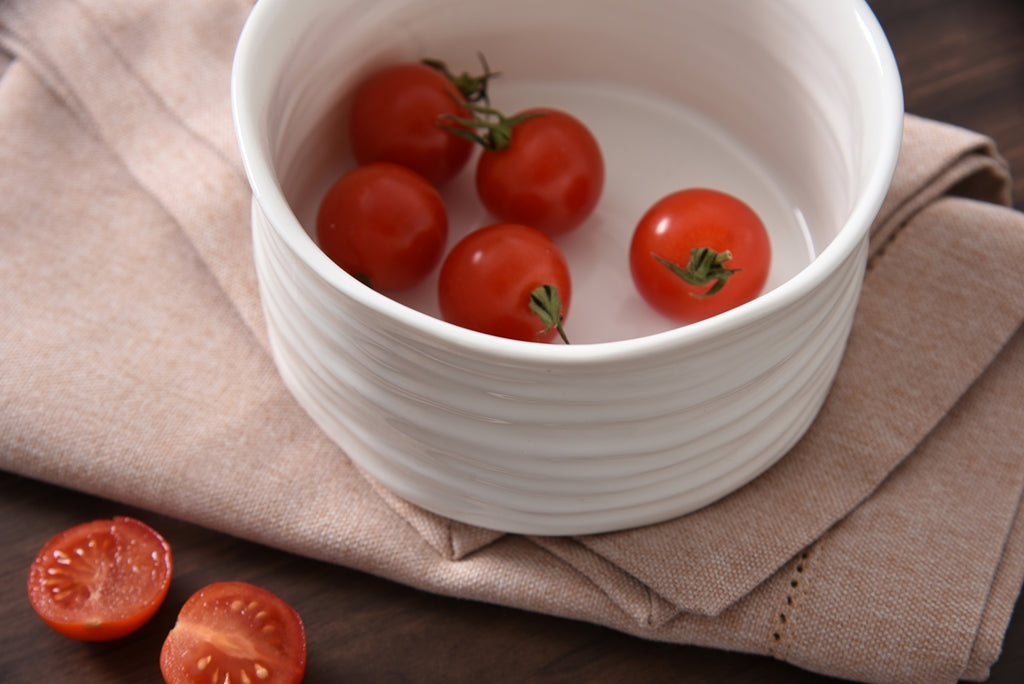White bowl with cherry tomatoes on a brown cloth
