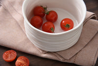 White bowl with cherry tomatoes on a brown cloth