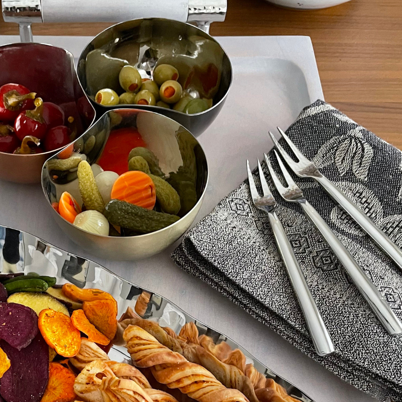 Versa cocktail forks displayed with an array of appetizers.