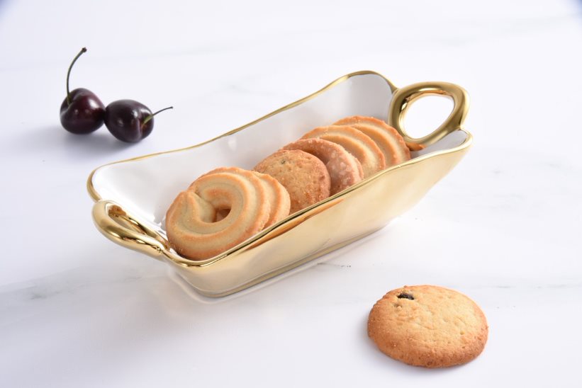 Gold tray with cookies and cherries on a white background