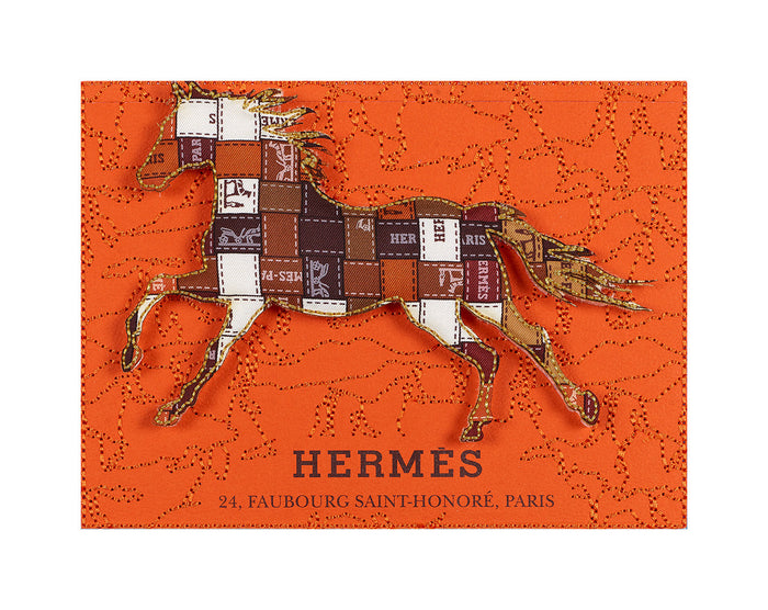 Designer-inspired Hermes collectible artwork featuring embroidered horse motif on orange box, framed in acrylic.