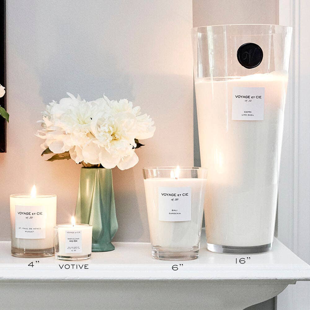 Candles and flowers on a shelf with a neutral background