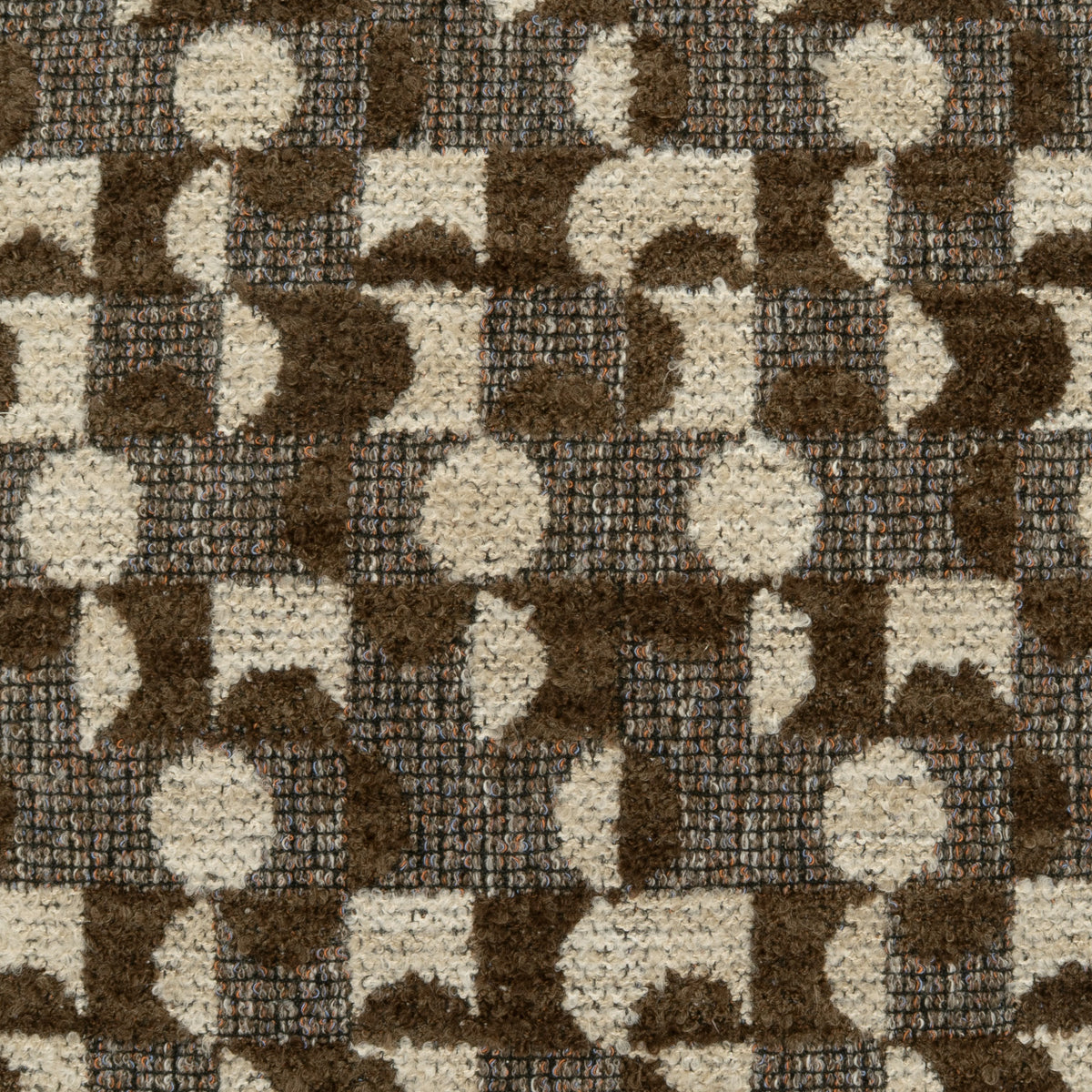 A close-up of a textured area rug with a geometric pattern of interlocking circles and semi-circles in dark brown and cream.