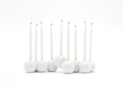 White candles with small round bases on a white background