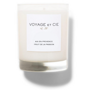 A clear glass jar candle with creamy off-white wax and a white rectangular label reading “VOYAGE ET CIE est. 202°°” and “LES ARRONDISSEMENTS 5ÉME QUARTIER LATIN SANTAL EPICER,” shown on a white background with a soft shadow.