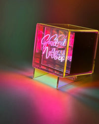 Neon sign with 'Good Vibes' text in a clear acrylic box on a dark background