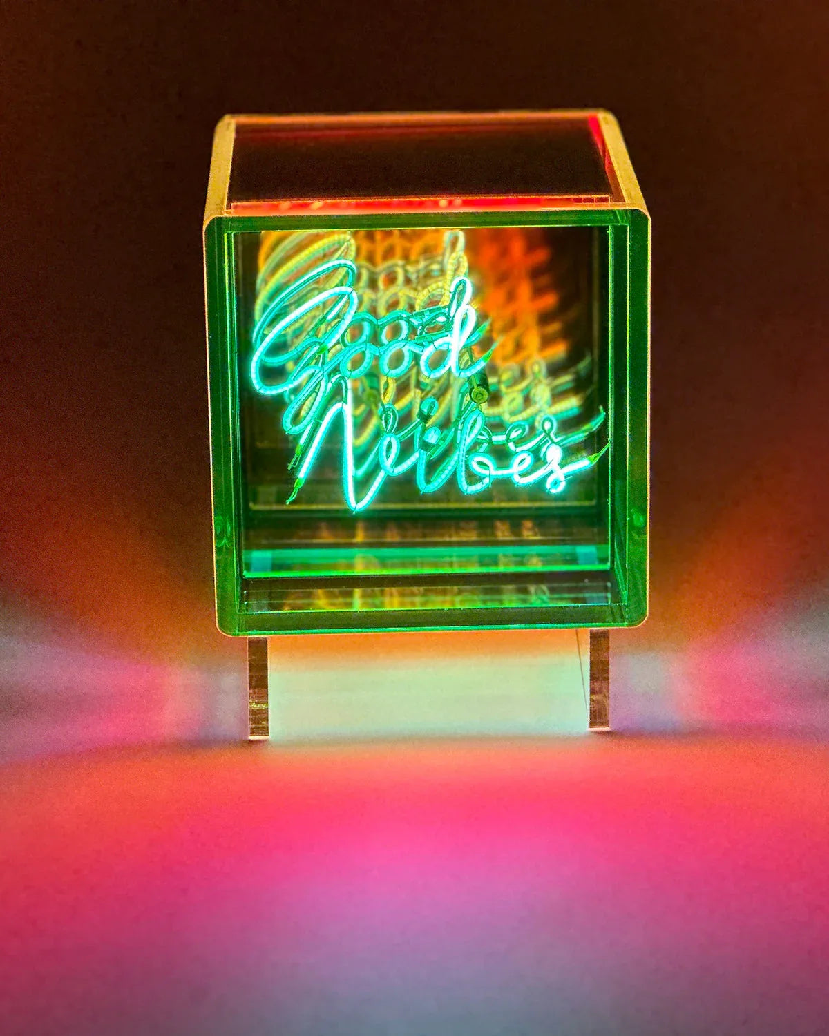 Neon sign with 'Good Vibes' text in a colorful box on a dark background