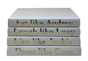 Stack of books with motivational quotes on a white background. Act like Audrey, Laugh like Lucy, Live Like Jackie, Dress like Coco