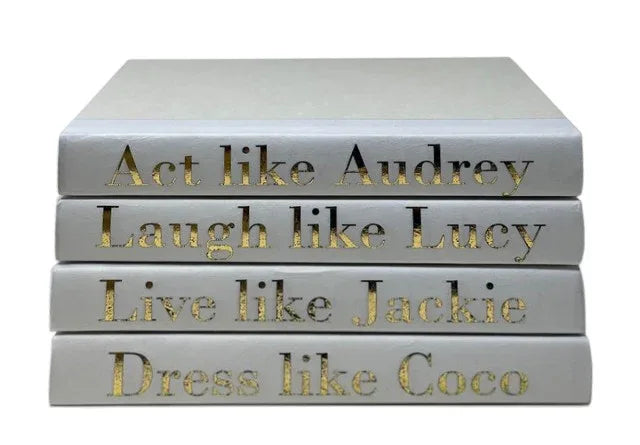Stack of books with motivational quotes on a white background. Act like Audrey, Laugh like Lucy, Live Like Jackie, Dress like Coco