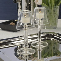 Ariel Tealight Lamp silver Votives Clear glass candle holders with candles on a reflective surface.