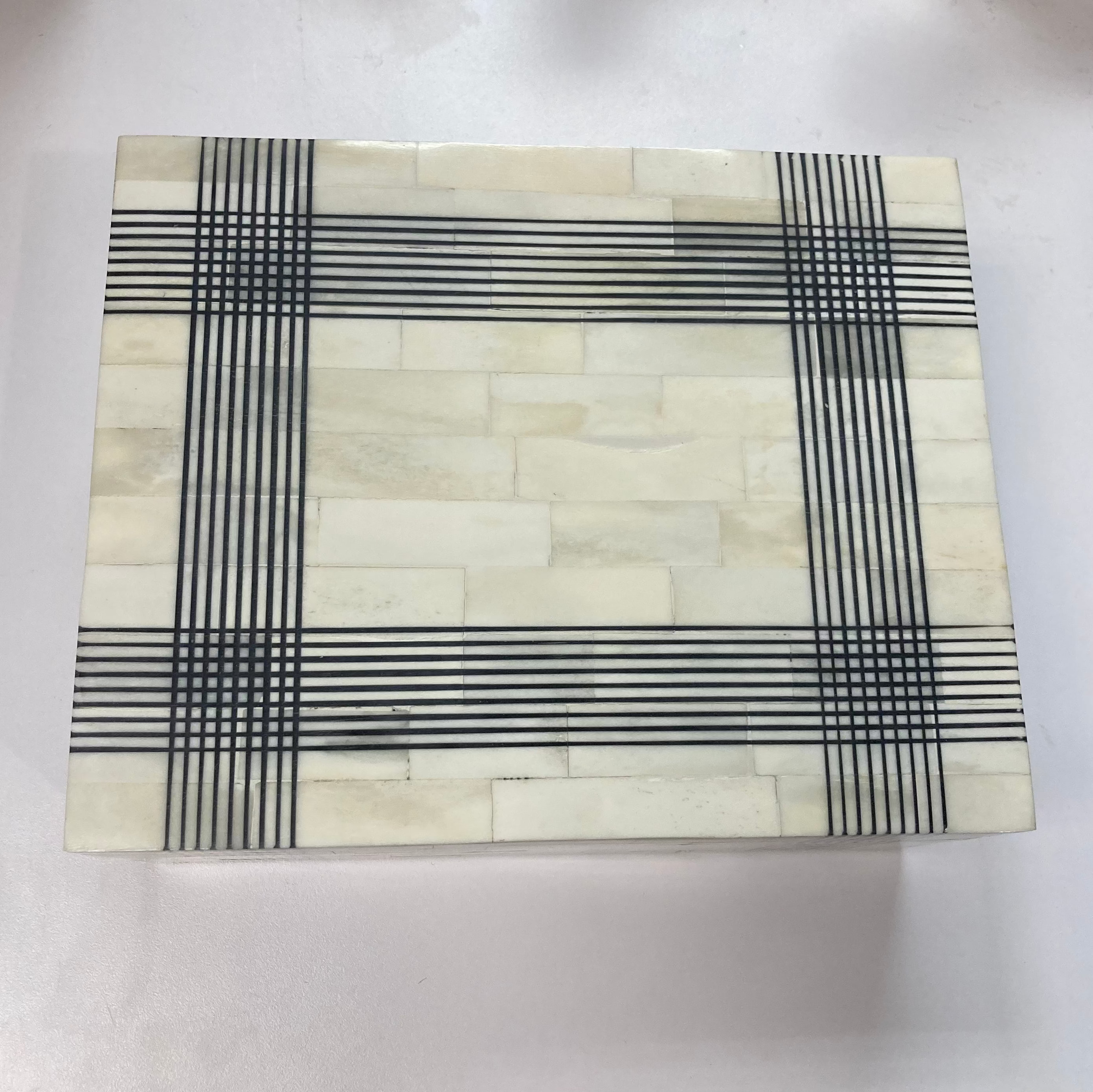 Rectangular stone coaster with black and white checkered pattern on a white background