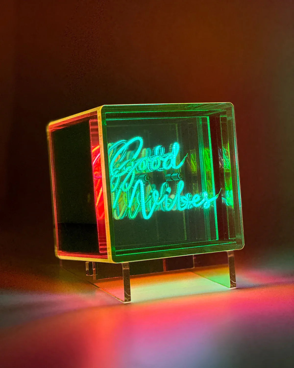 Neon sign in the shape of a cube with 'David Bowie' on a dark background