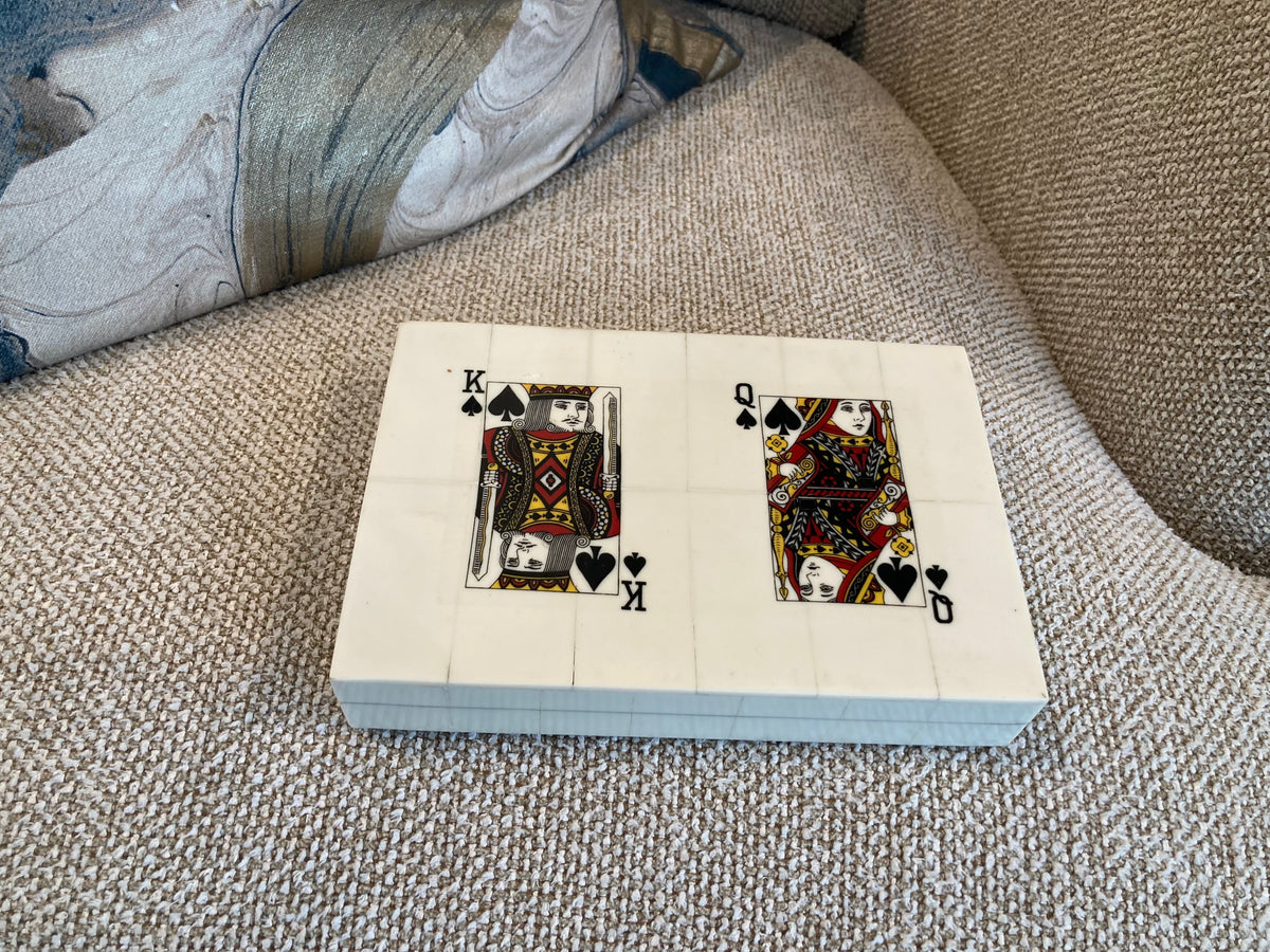 Playing card box with King of Spades design on a textured surface