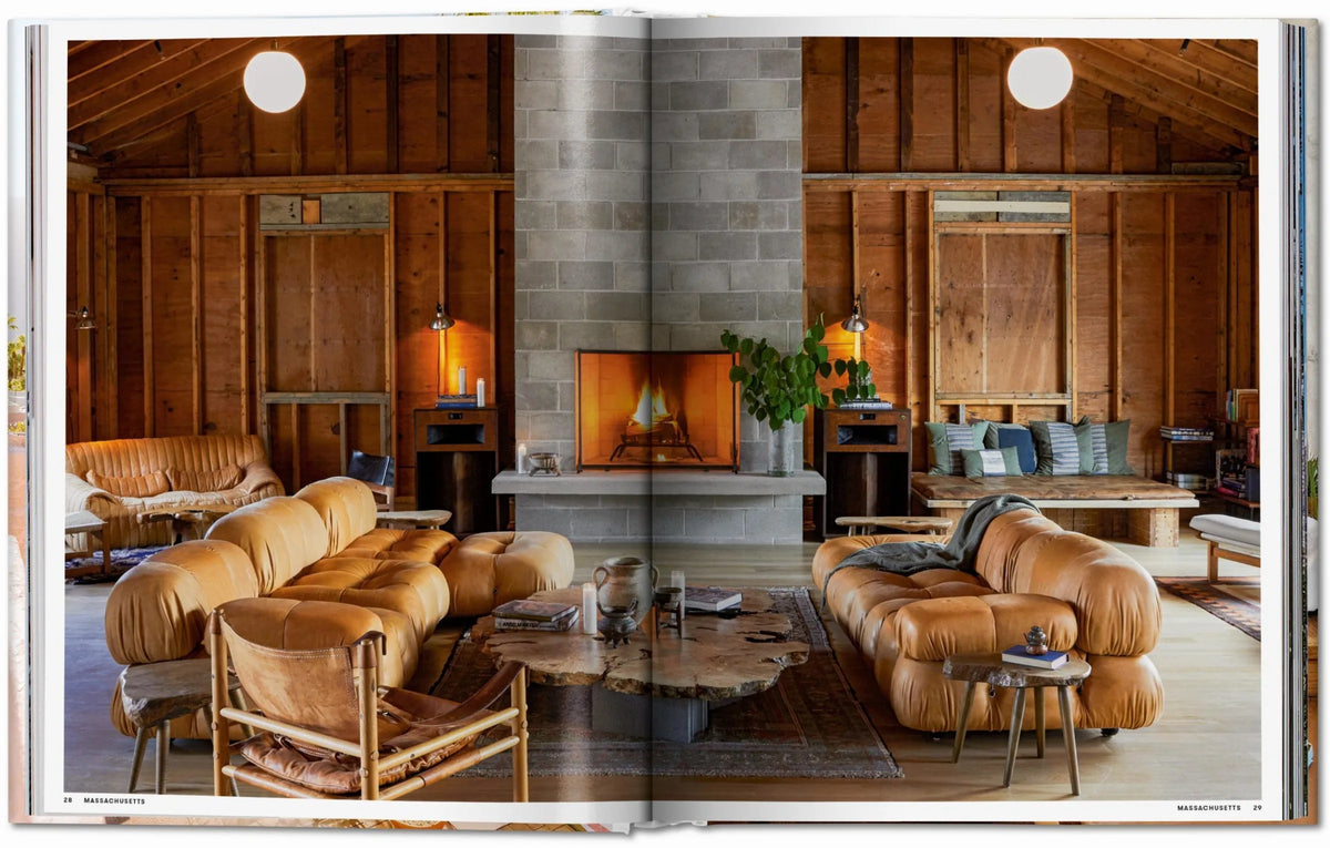 Open book showing a rustic living room with wooden walls, a fireplace, and brown furniture Luxury Ranch Decor & Mid-Century Modern Hotels