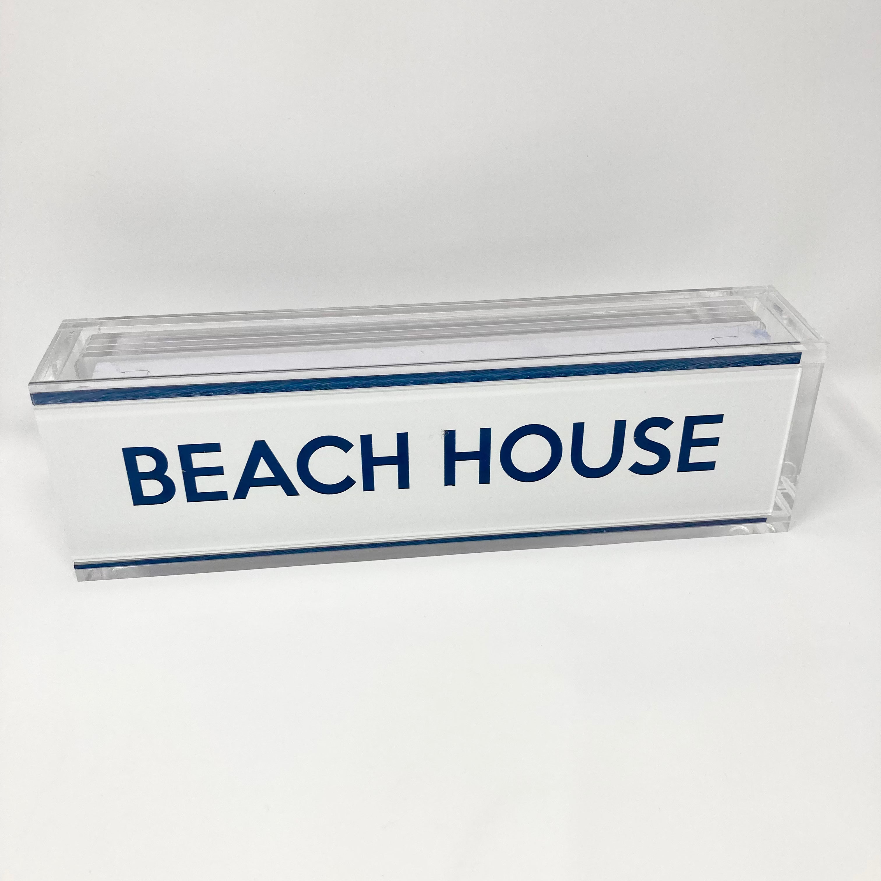 Rectangular glass block with 'BEACH HOUSE' text on a white background