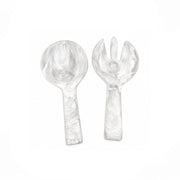 A clear glass serving spoon and matching glass serving fork with a marbled swirl pattern, displayed on a clean white background.