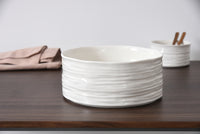 White ceramic bowl on a wooden surface with a neutral background