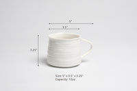 White ceramic mug with dimensions and capacity on a light gray background