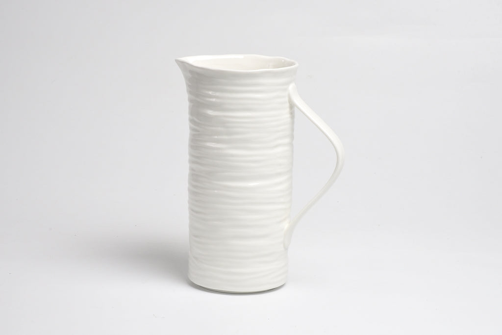 White ceramic pitcher on a light gray background