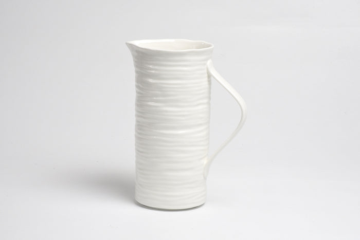 White ceramic pitcher on a light gray background