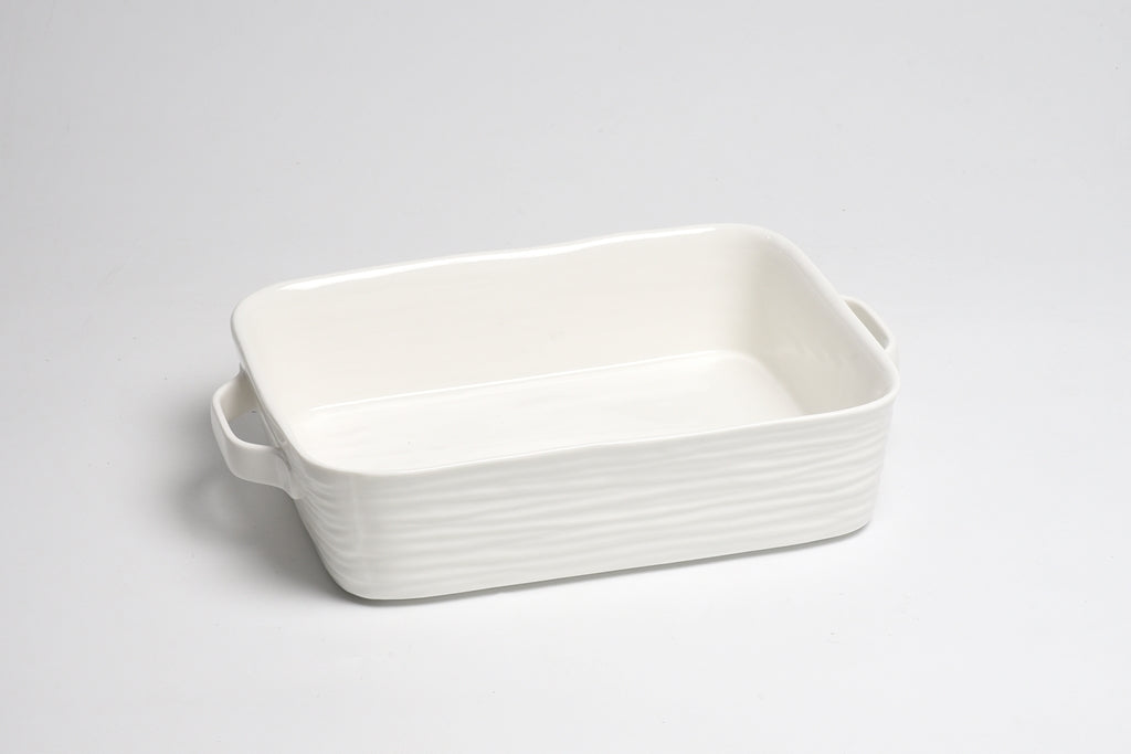 White rectangular ceramic dish with handles on a light gray background