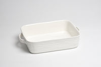 White rectangular ceramic dish with handles on a light gray background