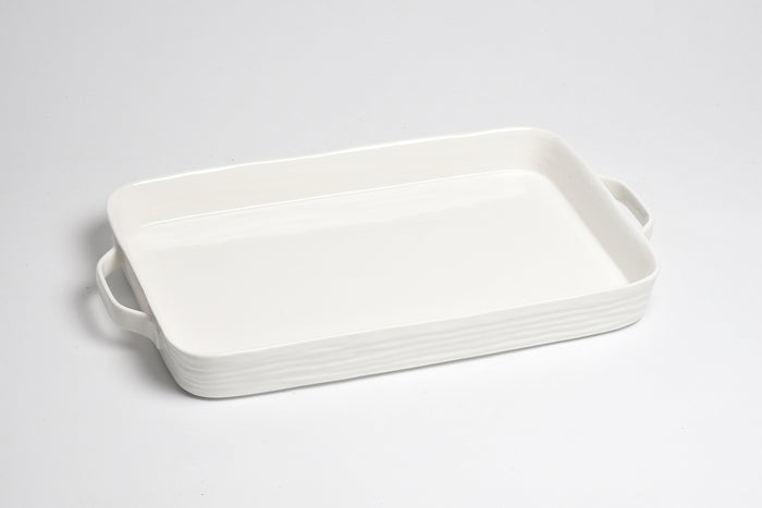 White ceramic baking dish with handles on a light gray background