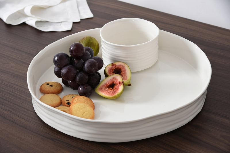 White ceramic tray with grapes, figs, and cookies on a wooden surface