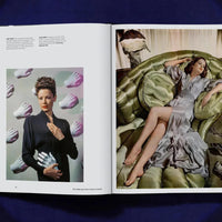 Open book showing two images: one of a woman in a black outfit with white gloves, and another of a woman in a gray dress lying on a green couch.