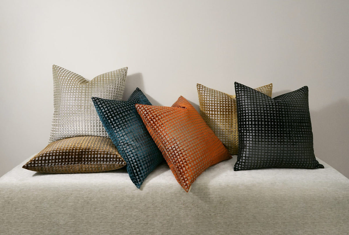 Collection of textured pillows in various colors on a light surface.