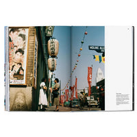 Open book showing a street scene with people, signs, and a clear sky. City of Angels Photography