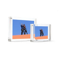 Two transparent acrylic photo frames displaying a photo of people on a desert background.