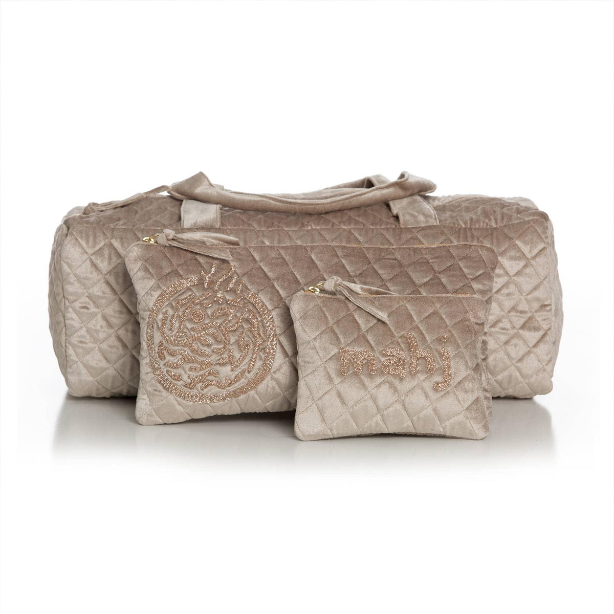 Quilted taupe 3 piece duffel bag with embroidered design on a white background