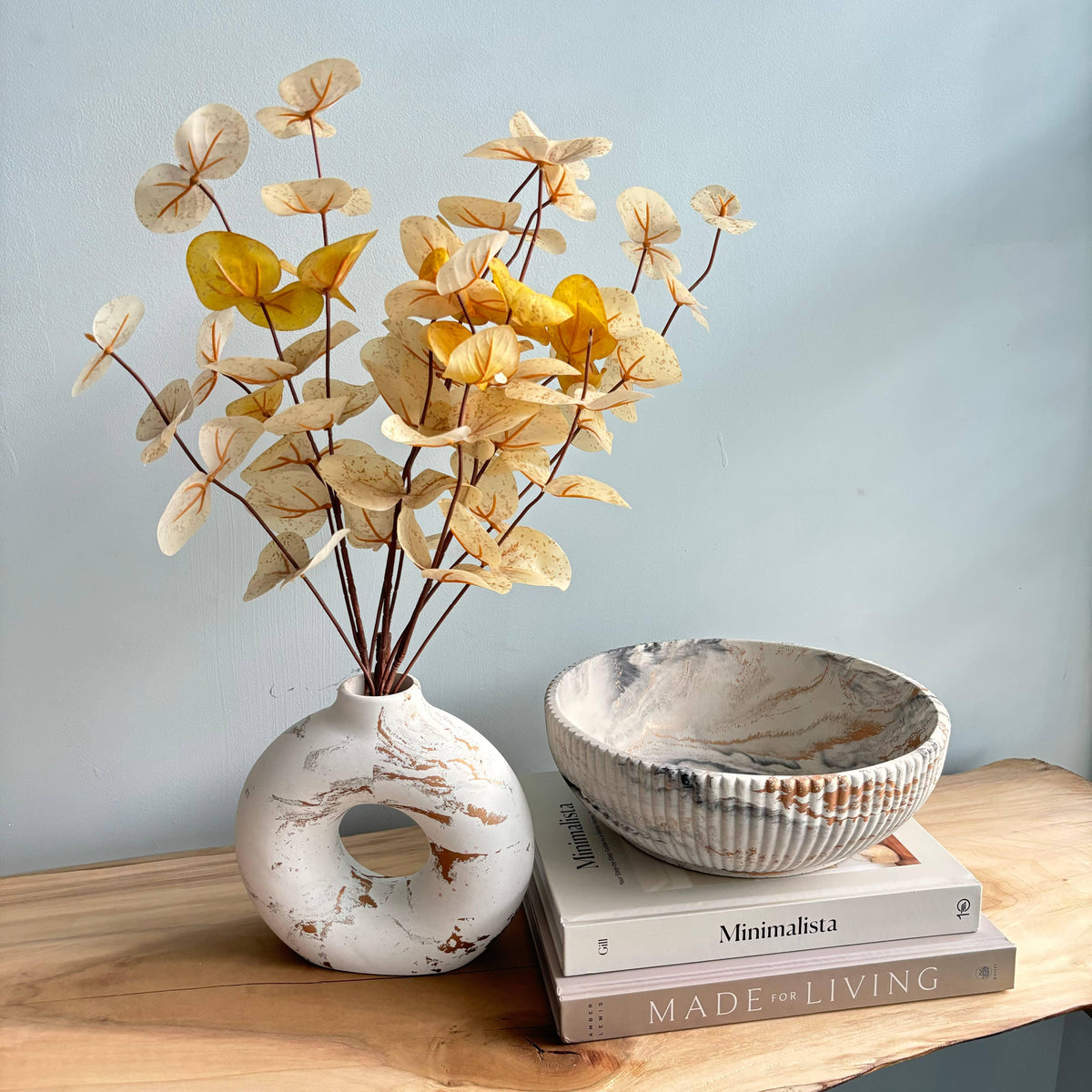 Marble Halo Vase Decorative with flowers, a bowl, and books on a wooden surface with a light blue background.
