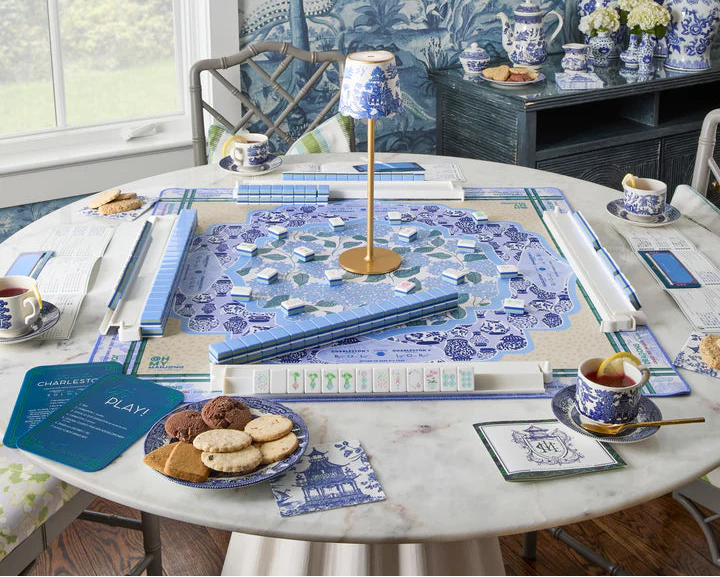 Dining room with a round table set for tea, featuring blue and white decor.