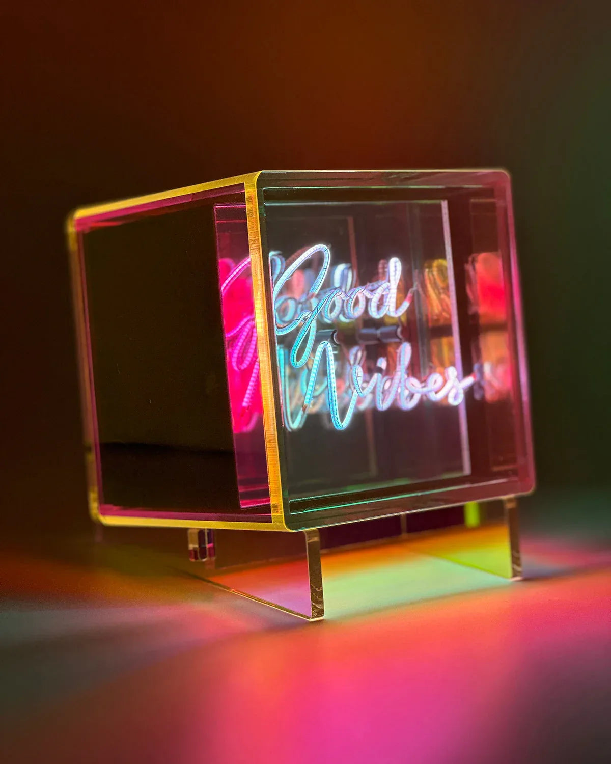 Neon sign with 'Good Vibes' text on a stand against a dark background