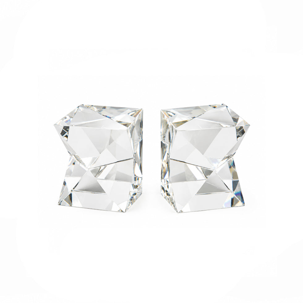 A pair of clear faceted crystal stud earrings shaped like stacked geometric cubes, shown on a plain white background.