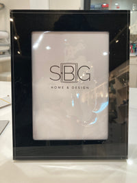 Black picture frame with SBG Home & Design logo on a white surface
