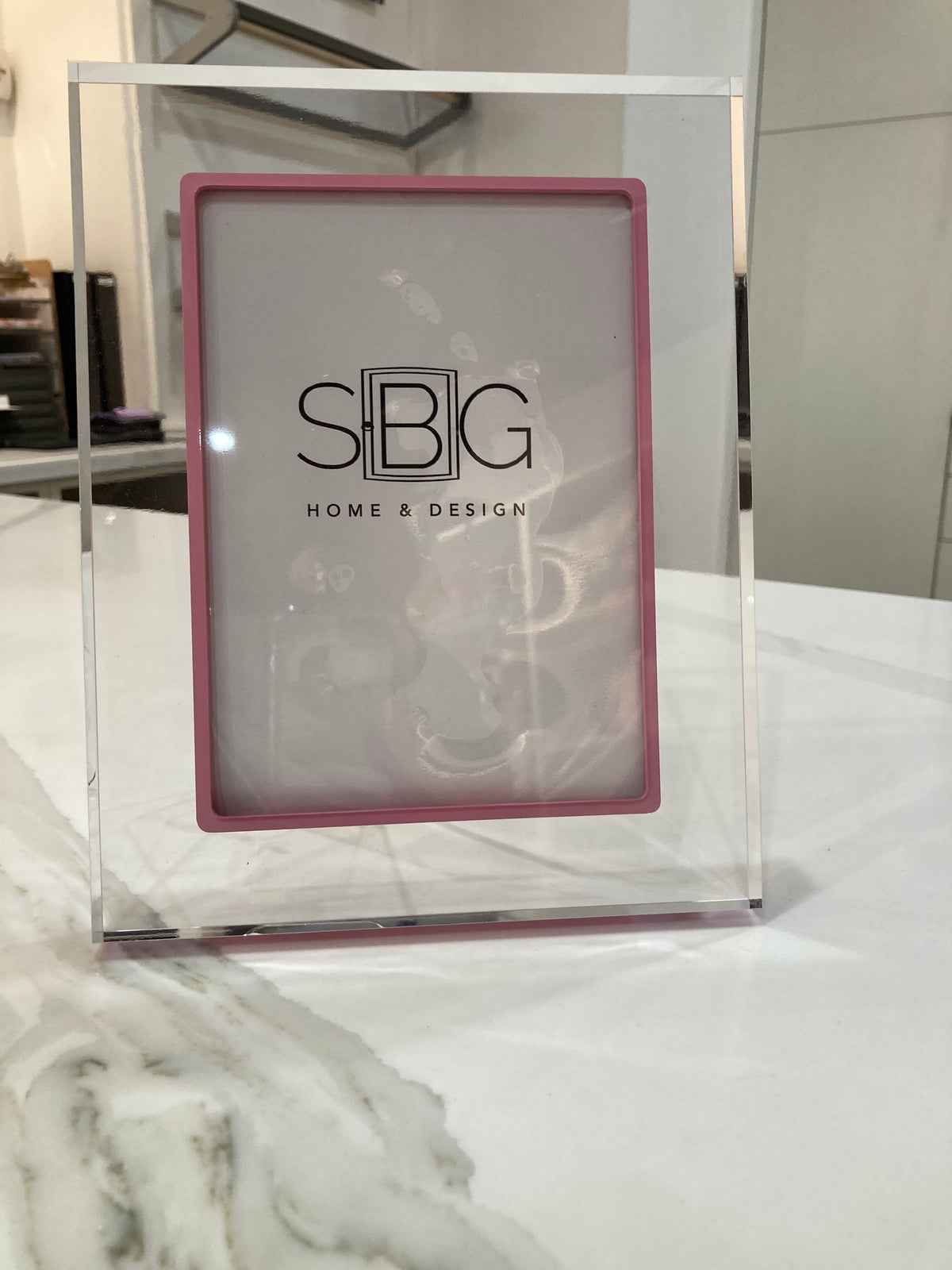 Haute Pink picture frame with SBG HOME & DESIGN logo on a marble surface