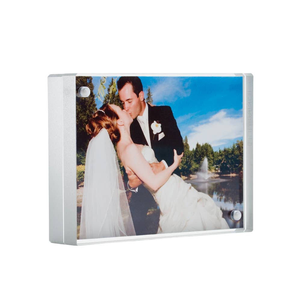 Acrylic photo block silver edge magnetic two sided frame with a wedding couple embracing in front of a office background.
