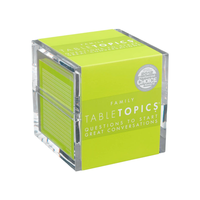 A cube-shaped card deck box for Family Table Topics, featuring a bright lime green front and side panel with white text, a silver 2012 Good Housekeeping Choice award seal, and a clear acrylic outer casing, shown on a white background.