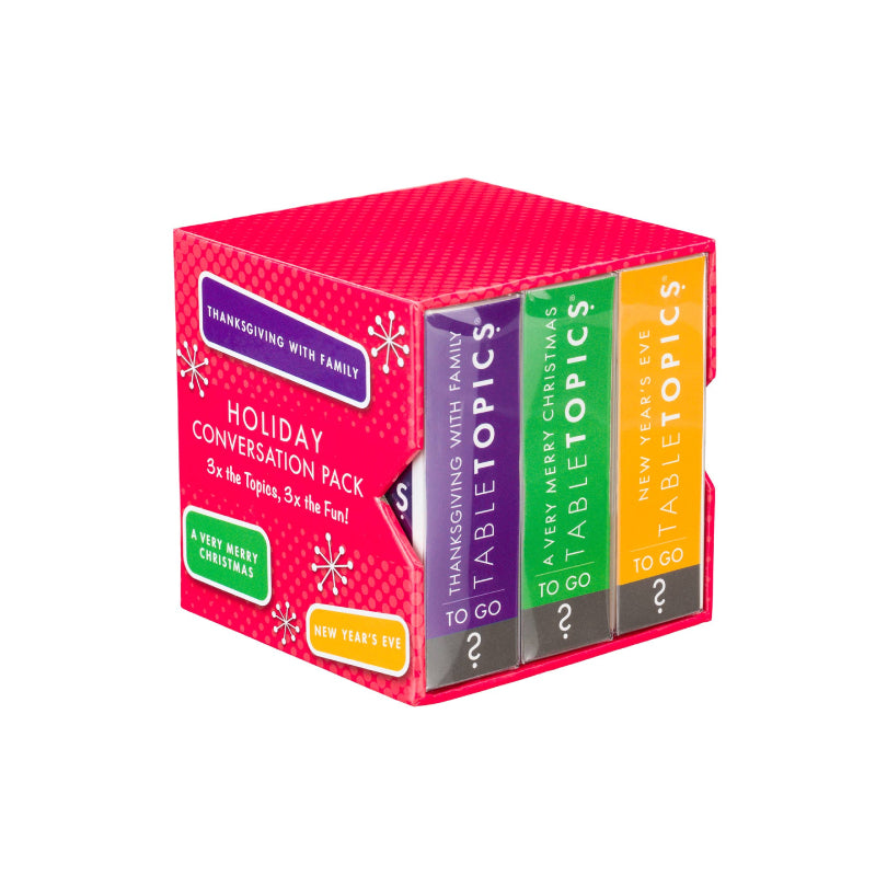 TableTopics Holiday Conversation Pack box showing four colorful book spines: Thanksgiving with Family, A Very Merry Christmas, New Year's Eve, and To Go. The packaging is bright pink with white snowflake graphics.