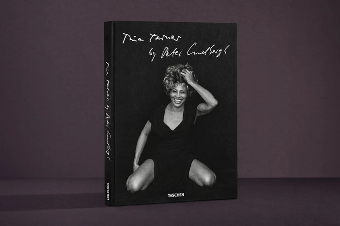 Book cover with a black and white photo of a woman sitting, on a dark purple background Tina Turner by Peter Lindbergh Books Music History Gift