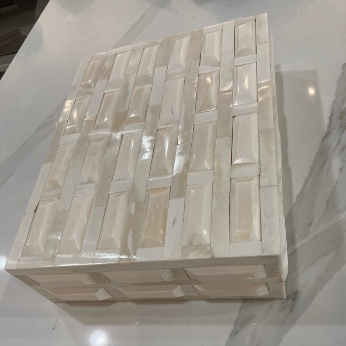 Decorative stone box with geometric pattern on a marble surface