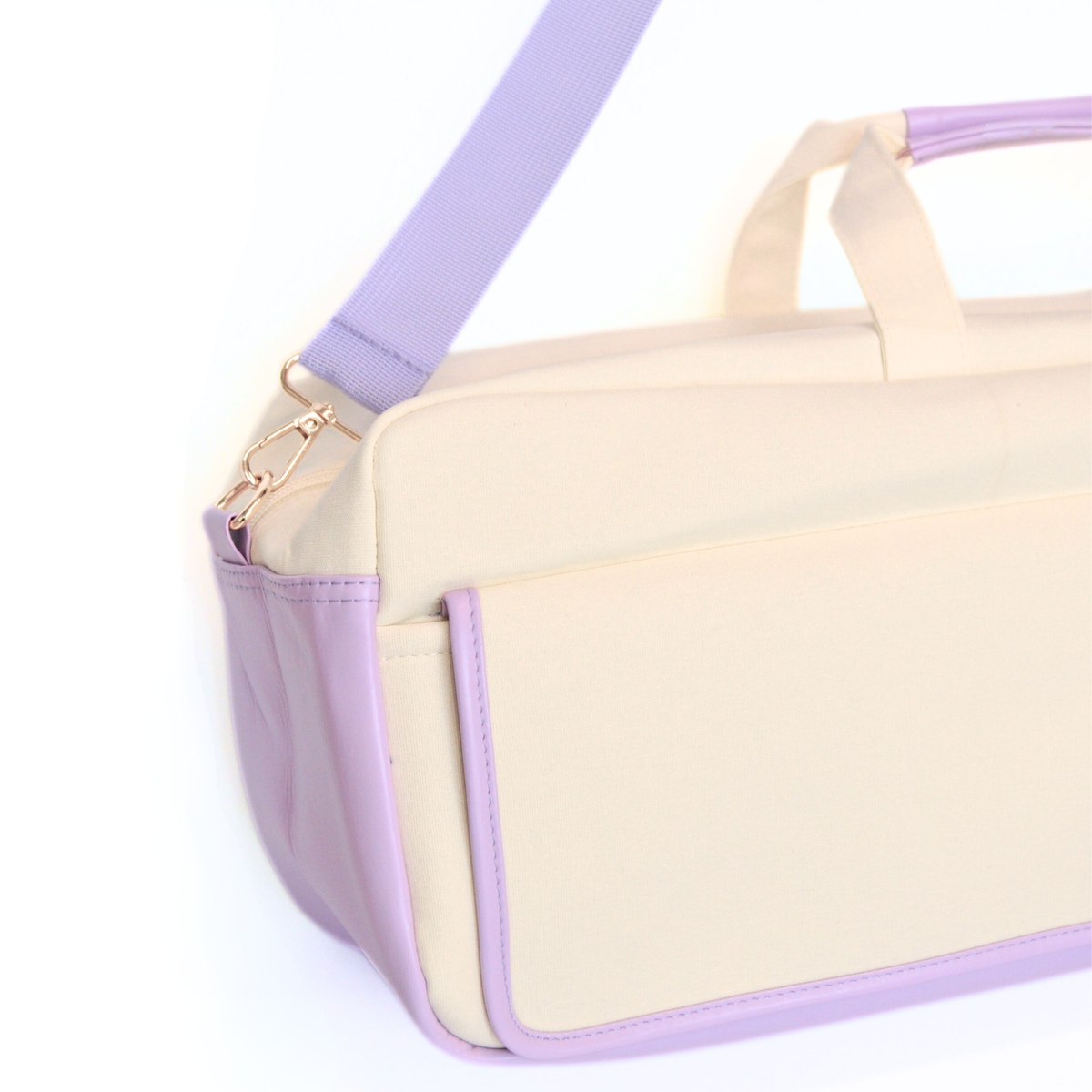 Beige and purple handbag with a strap on a white background