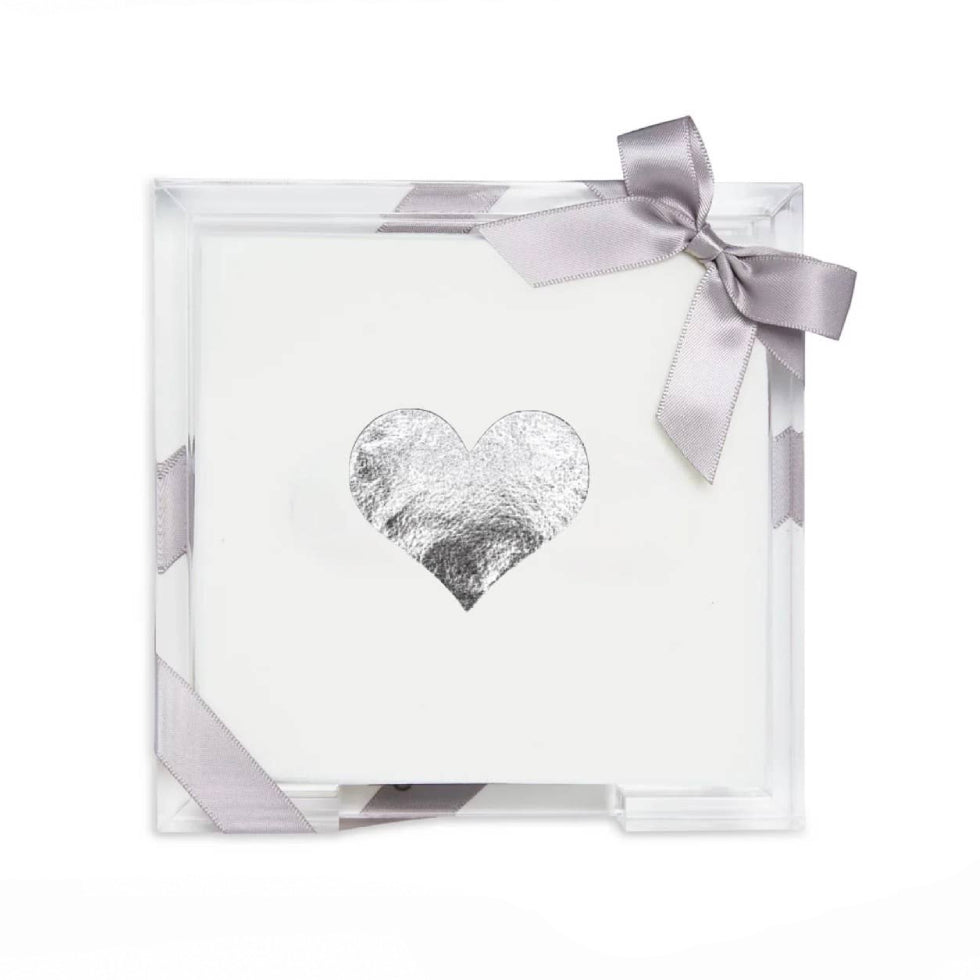 A square white gift box with a clear acrylic front, decorated with a silver foil heart in the center and tied with a light purple satin ribbon bow.