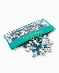 Set of mini mahjong tiles with a teal pouch on a white background