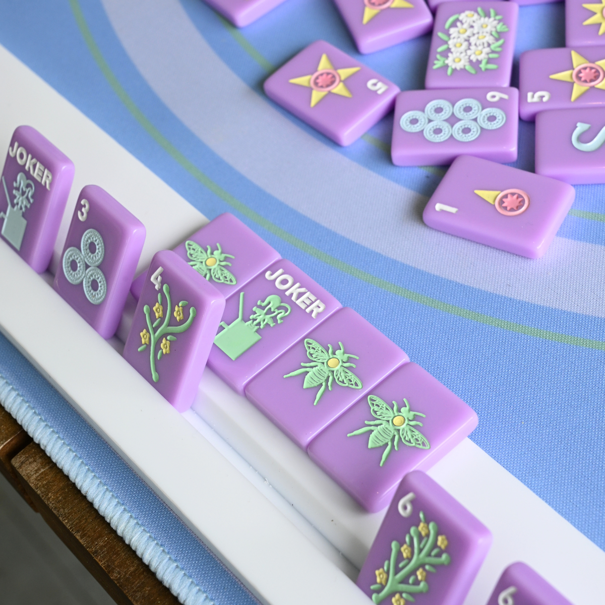Close-up of purple game mahjong tiles with various symbols on a blue game board