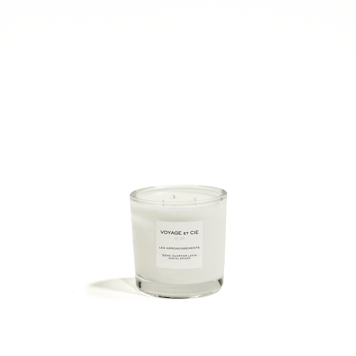A white soy wax candle in a clear glass jar with a white label reading 'VOYAGE et CIE' on a clean white background.