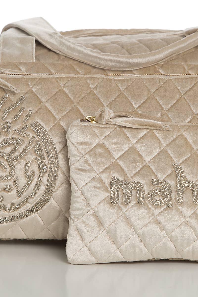Quilted silver handbag with 'maj' embroidery on a light background